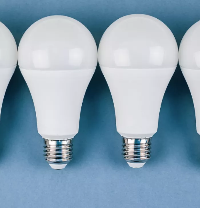 A row of LED lightbulbs on a plain blue background