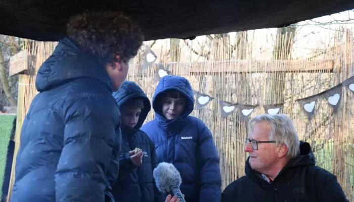 3 children from Goat Lees chatting with Rob Smith by the fire outside.