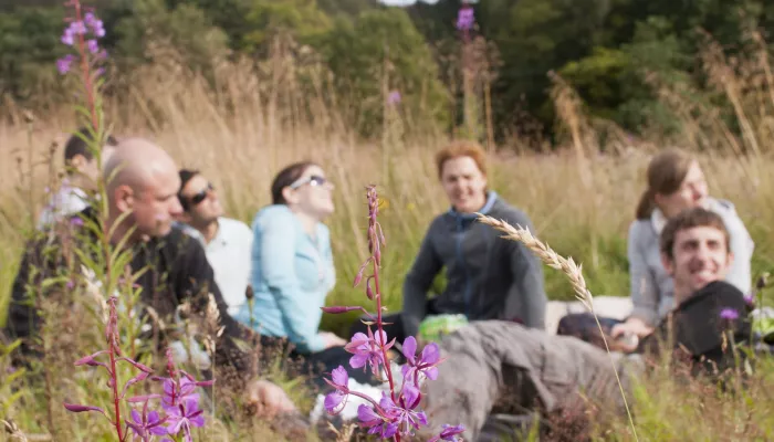 flowers in foreground with people smiling and laughing in background