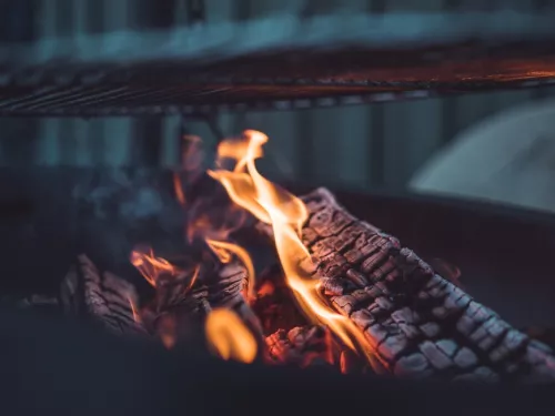 Close up of lightly flaming logs on a warm fire.