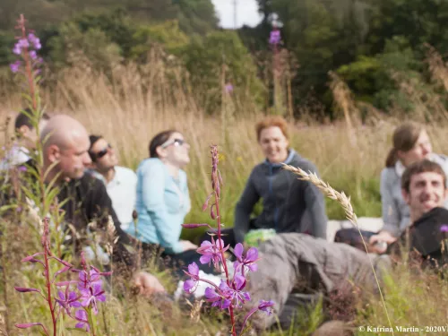 flowers in foreground with people smiling and laughing in background