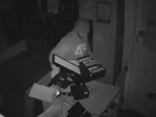 CCTV still showing man snatching the till