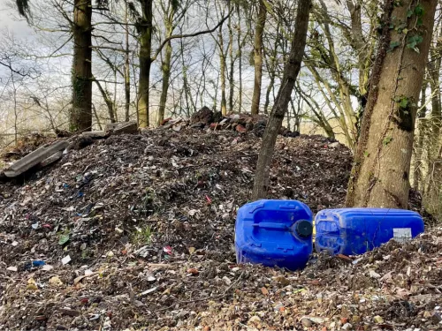 Hoad's wood fly tipping pile with blue plastic containers in foreground